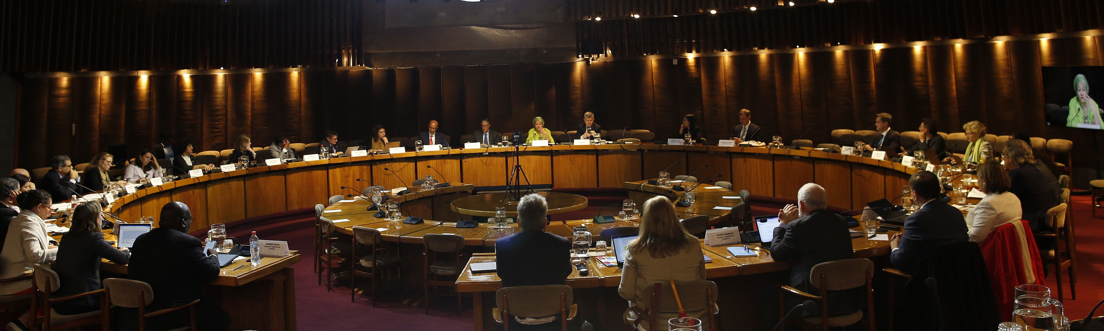 RC's sit around a table, there are flags behind them