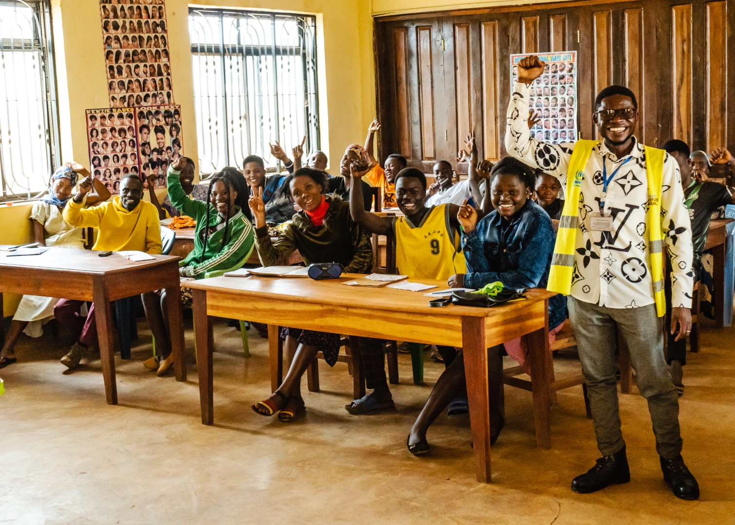 A group of young people are in a classroom and look at the camera and smiling