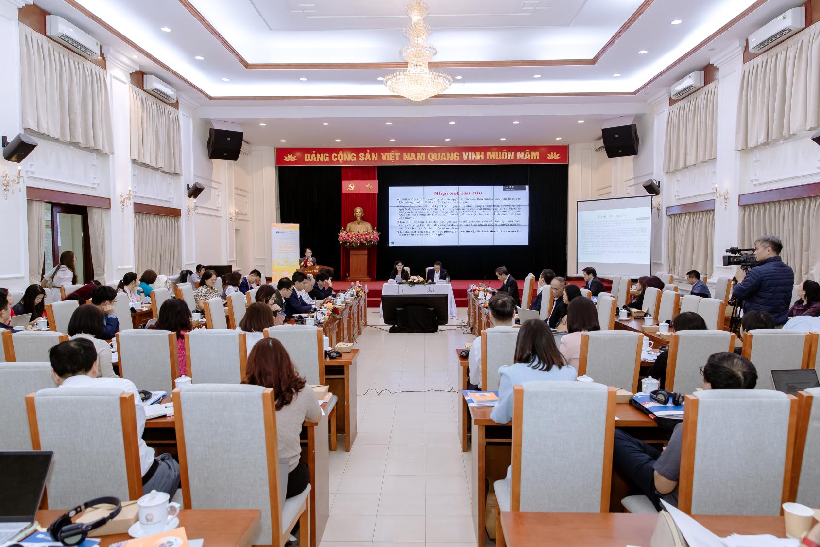 A group of people in an auditorium watching a presentation