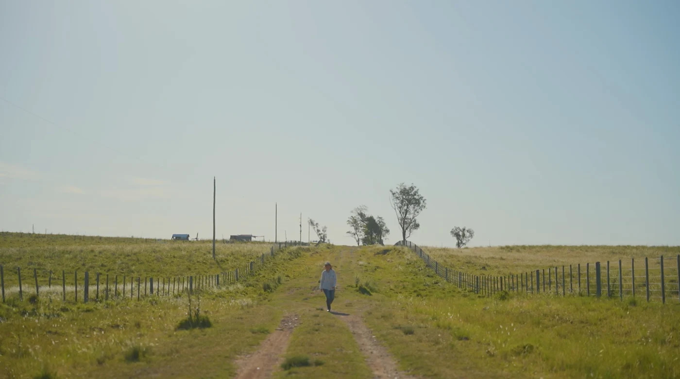 A long-shot photo of a woman in a field in Uruguay.