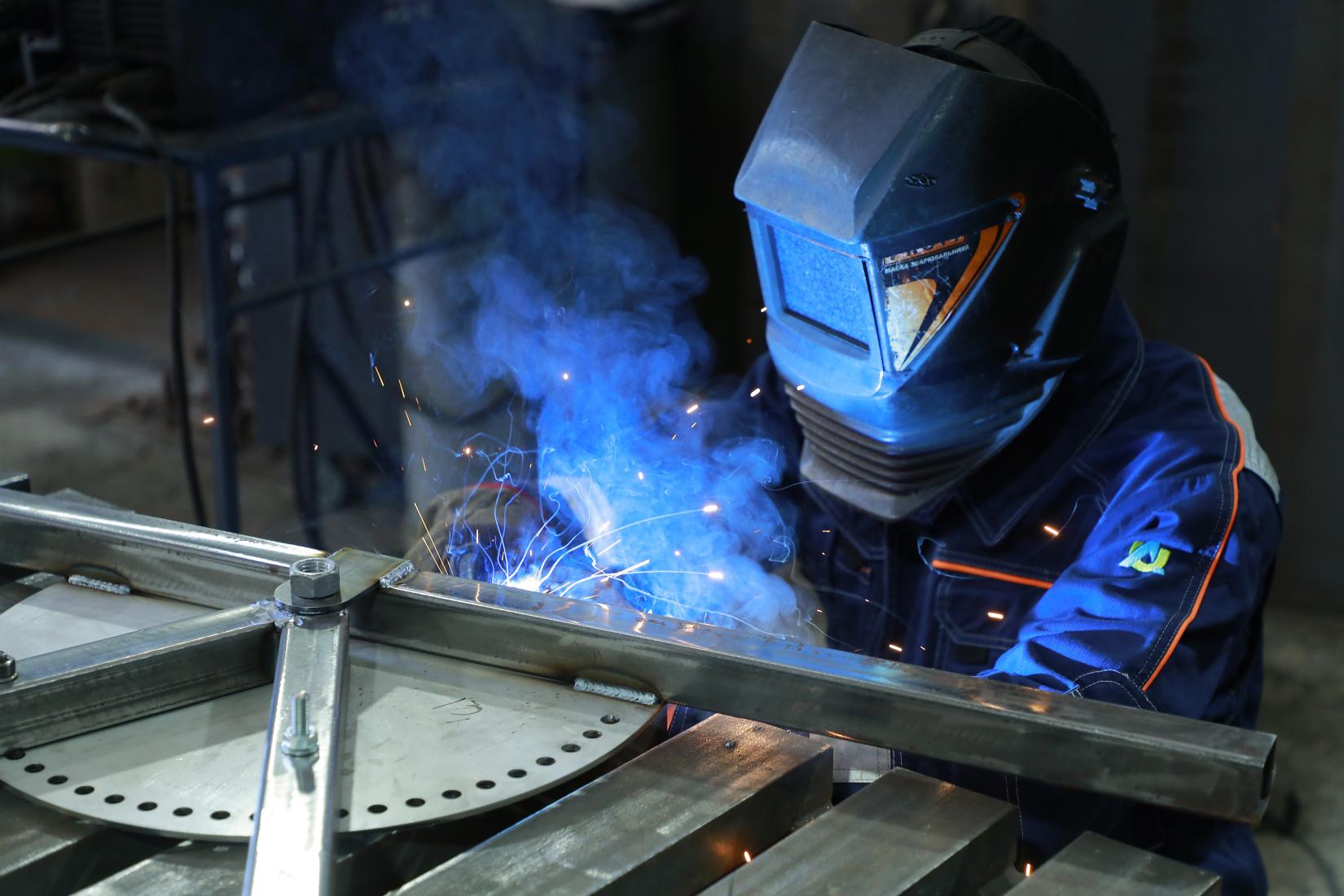 A worker in Ukraine welds in a workshop.