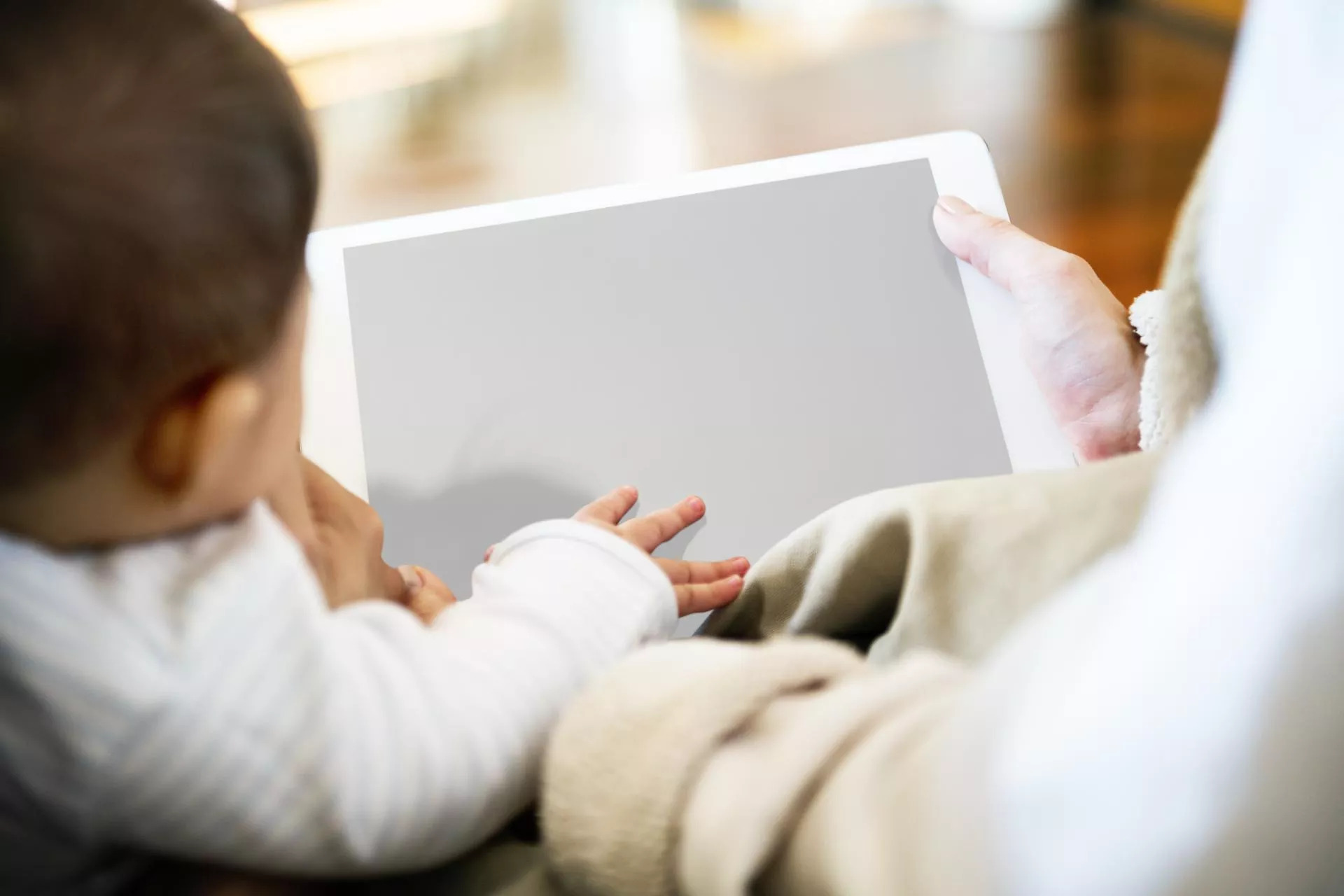 A child uses a tablet with his parent.