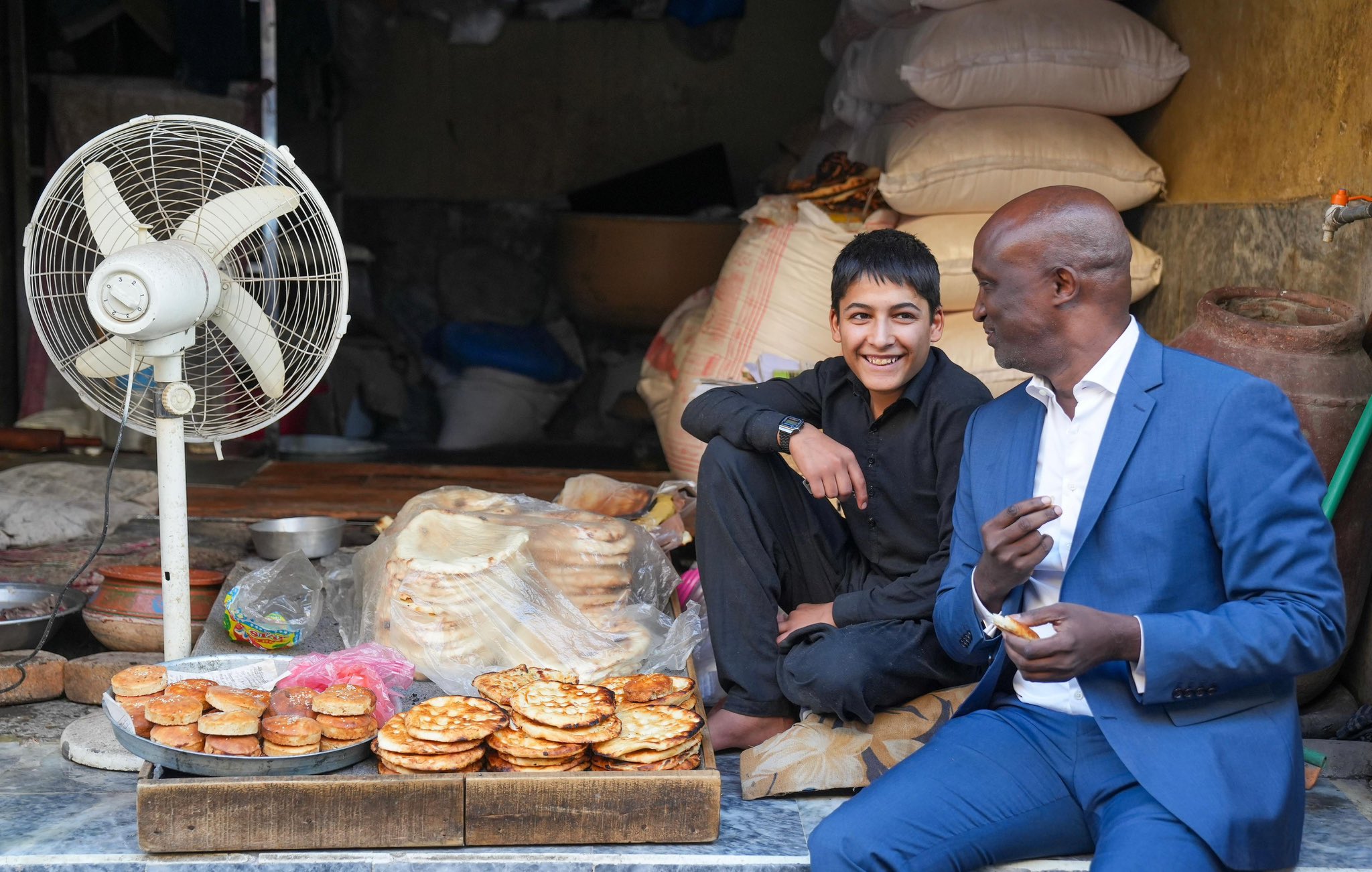 The Resident Coordinator in Pakistan talks to a boy selling food.
