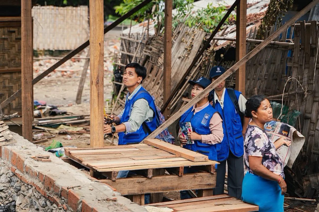 Volunteers in Myanmar surveil a building being rebuilt after an earthquake.
