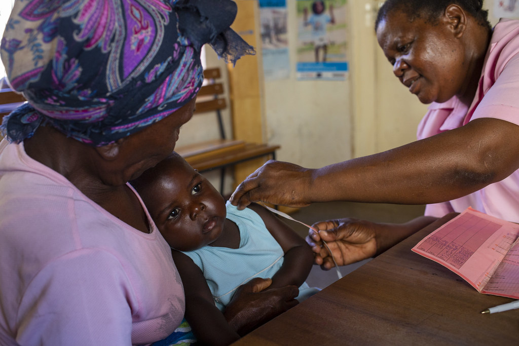 A baby in Zimbabwe receives a vaccine as she sits in her grandmother's arms.