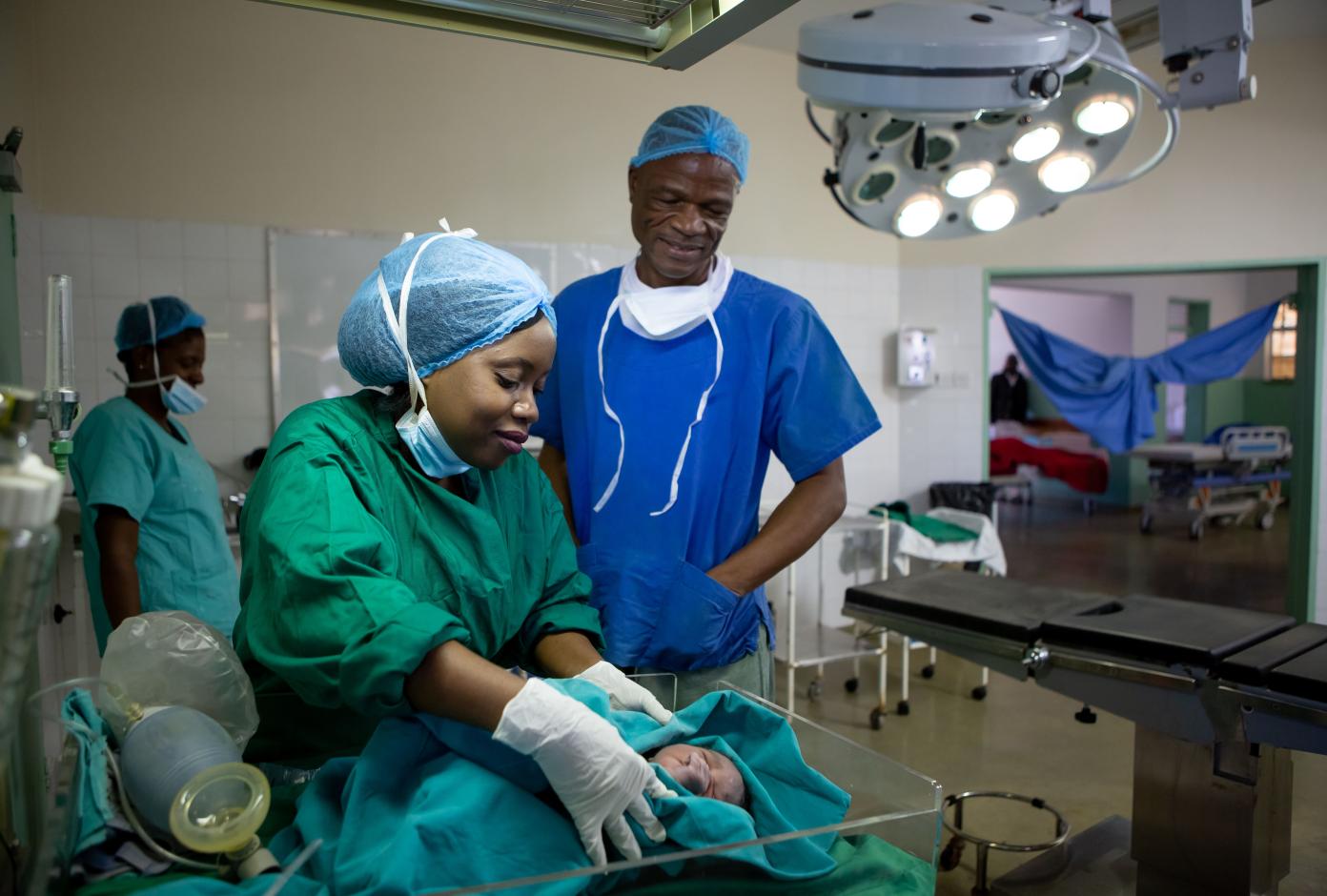 A nurse and a doctor attend to a baby in Zimbabwe.
