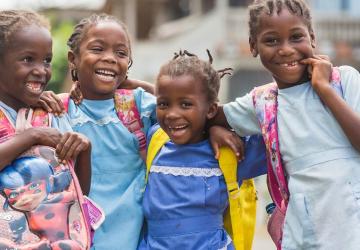 group of young children standing in a group with their arms around each other 