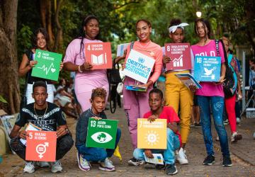 group of young people holding colourful SDG signs. 