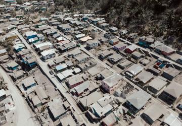 birds-eye view of building covered in ash and half destroyed 