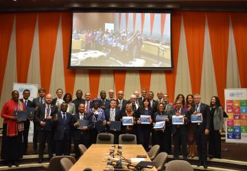 group photo of people standing in meeting meeting room holding on to prizes and looking into the camera