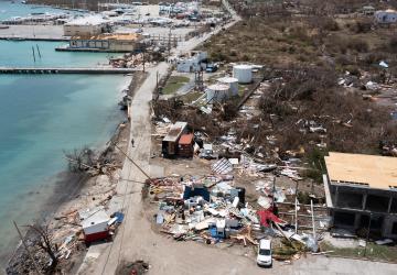 A devastating scene by the waterfront, showing houses and buildings damaged