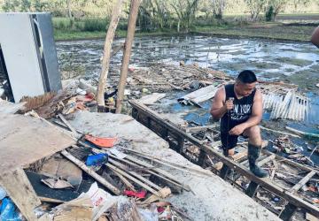 A man dealing with the aftermath of a Typhoon with debree etc 