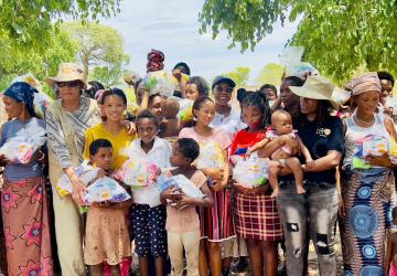 A group of people standing outdoors holding children