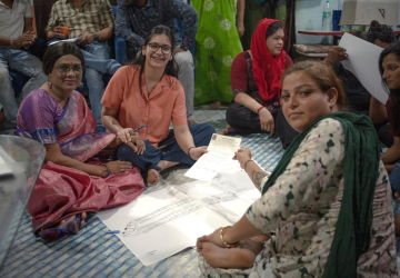 A group of people in an indoor setting congregating around a document