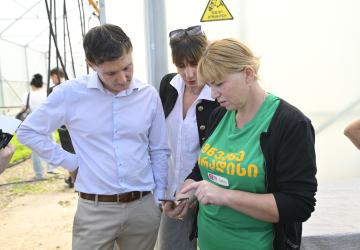Naira Paksadze, a member of the women-led Green Maradisi cooperative, demonstrates the GECSA app to UN Resident Coordinator Didier Trebucq.