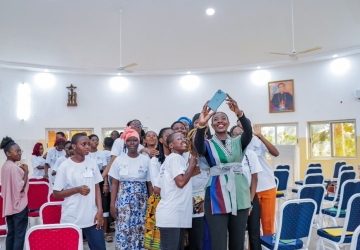 A high-level UN official takes a photo with female high school students in Togo.