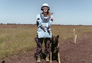 A deminer in Ukraine and her demining assistance dog.