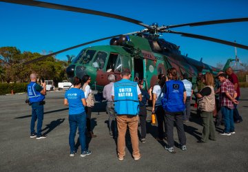 Members of the UN team in Cuba and partners in front of a helicopter.