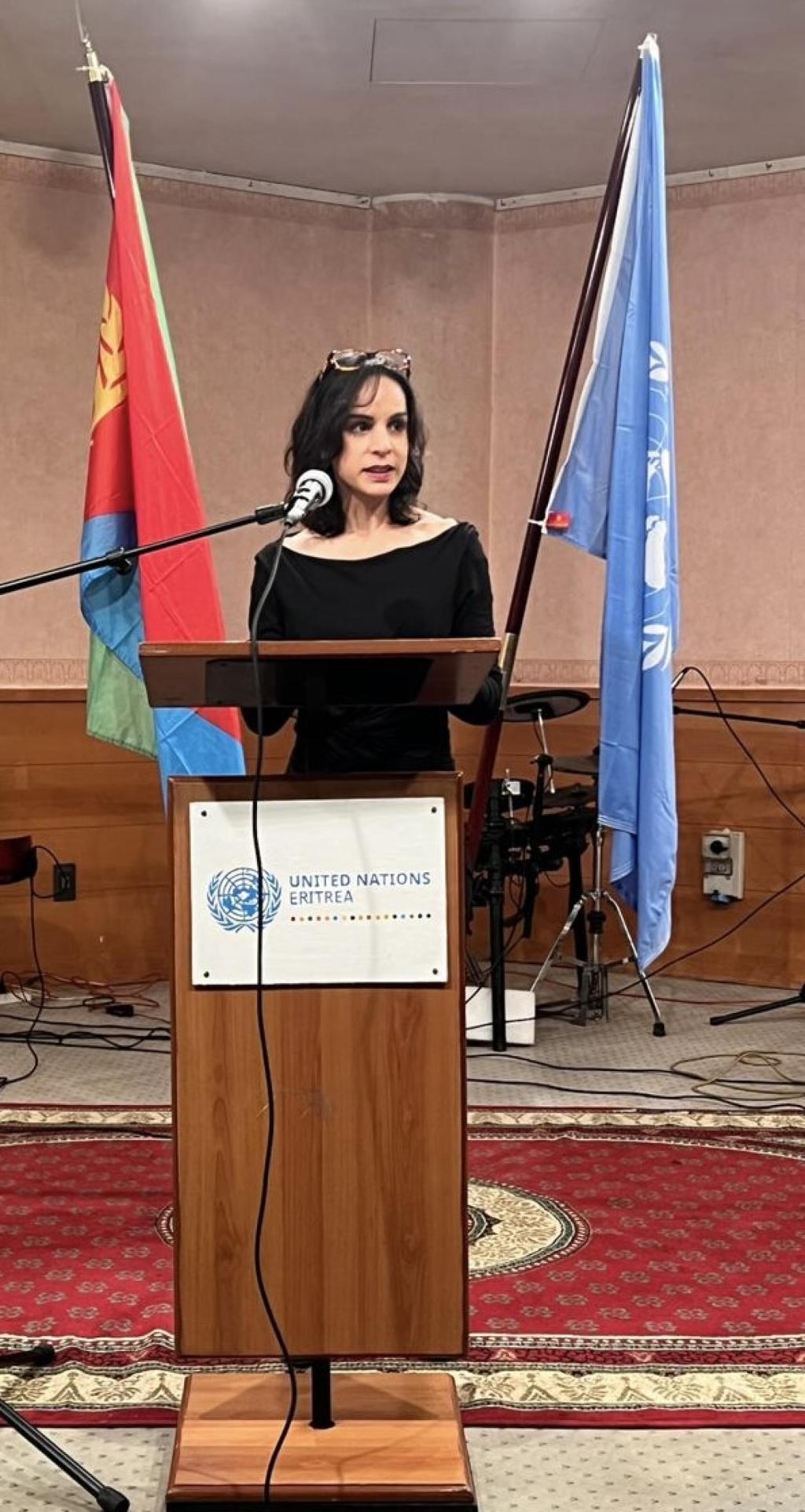 The Resident Coordinator in Eritrea is speaking at a lectern with the Eritrean and UN flags behind her