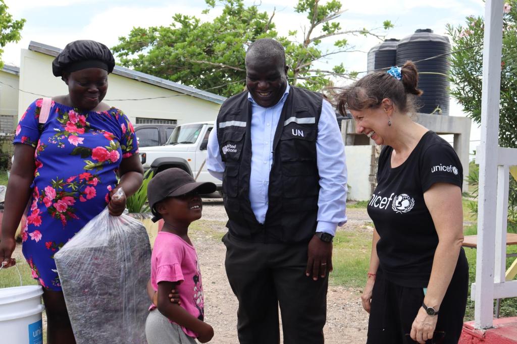 The RC is speaking to a young girl and a lady wearing a UNICEF shirt 
