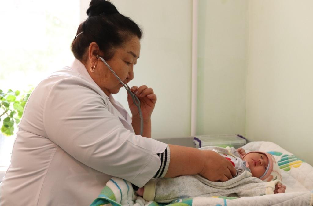 A doctor in Kyrgyzstan examines a baby.