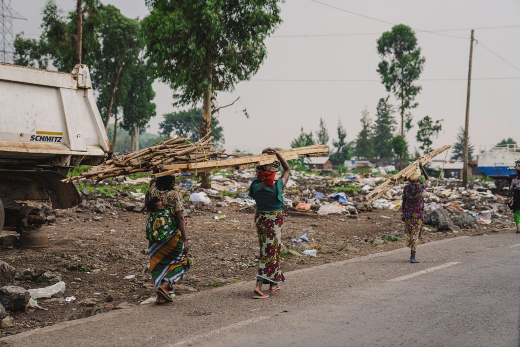 Three women in the DRC carry building materials.