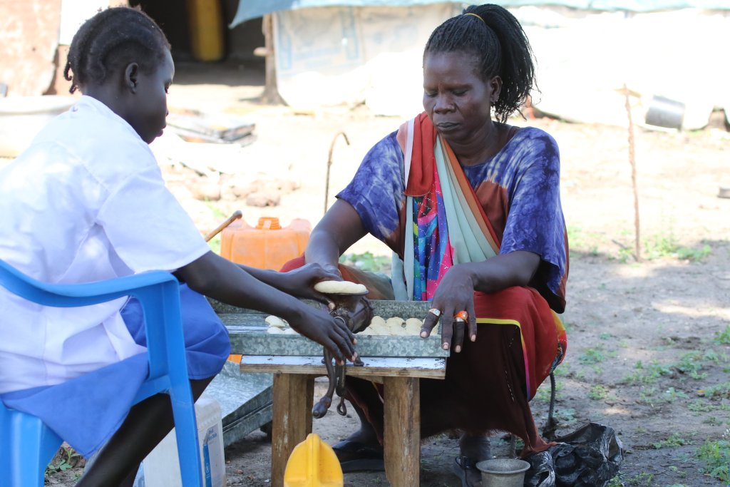 A woman in South Sudan bakes cookies with her daughter.