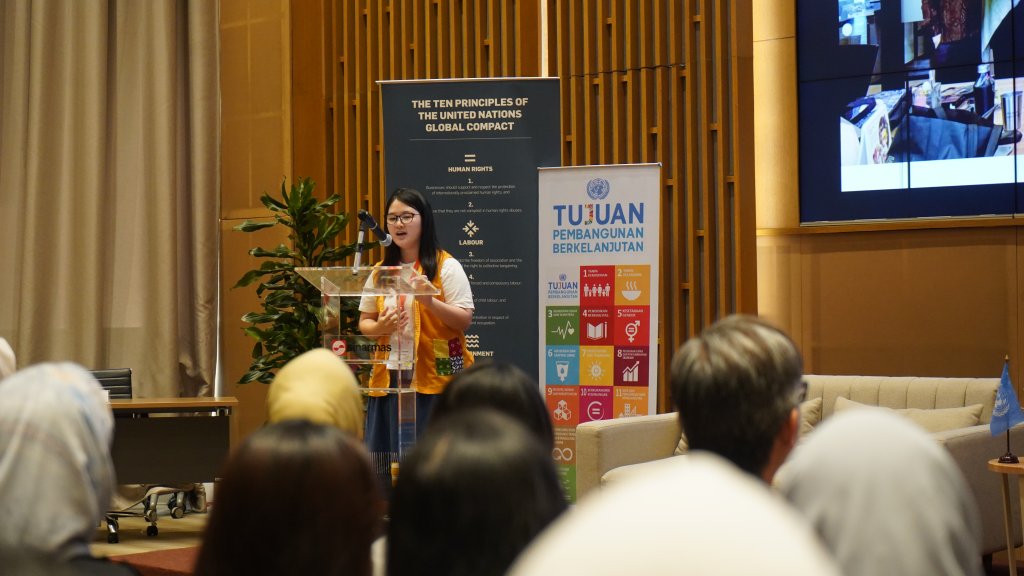 A young woman leader in Indonesia gives a speech at an event.