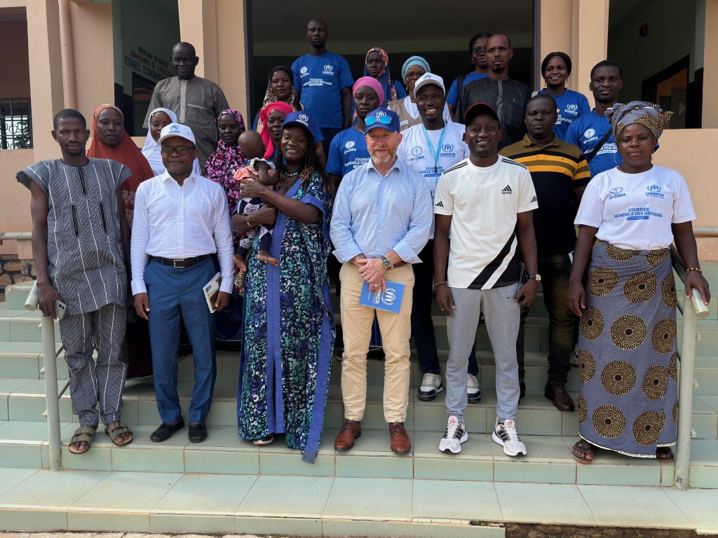 Local community members in Benin take a group photo with UN officials.