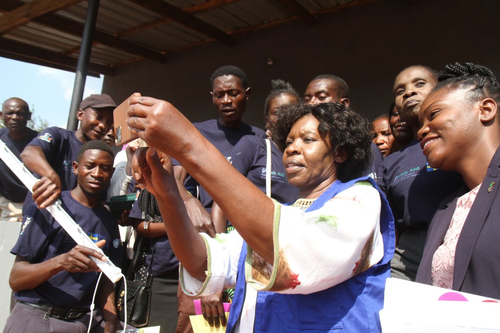 The UN Resident Coordinator in Zambia takes a photo with local community members.