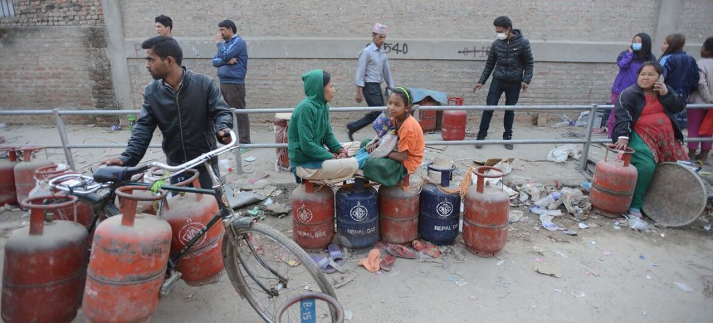 People in Nepal line up with fuel canisters. 