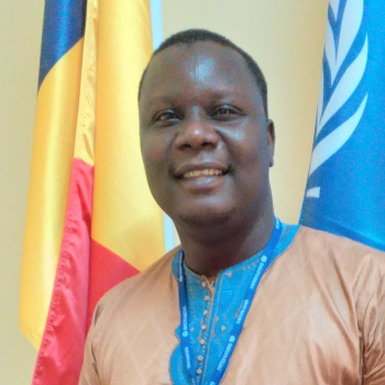 Man stands in front of UN and Chadian flag 