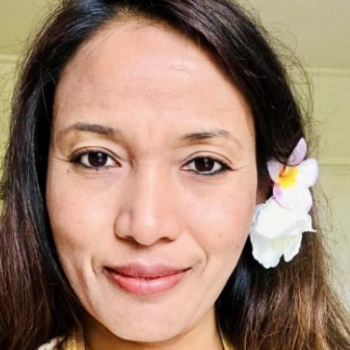 woman with dark hair and flower 