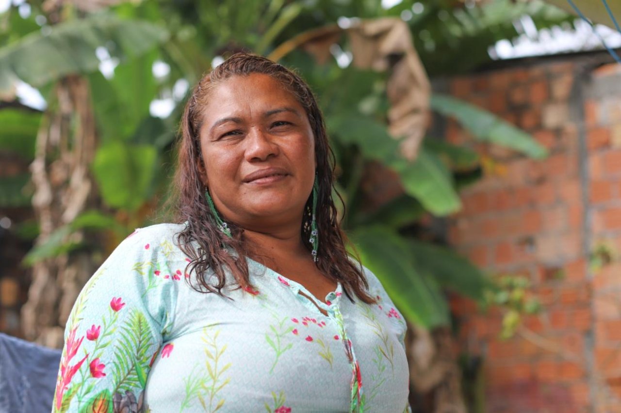 woman standing in front of tree smiles to the camera
