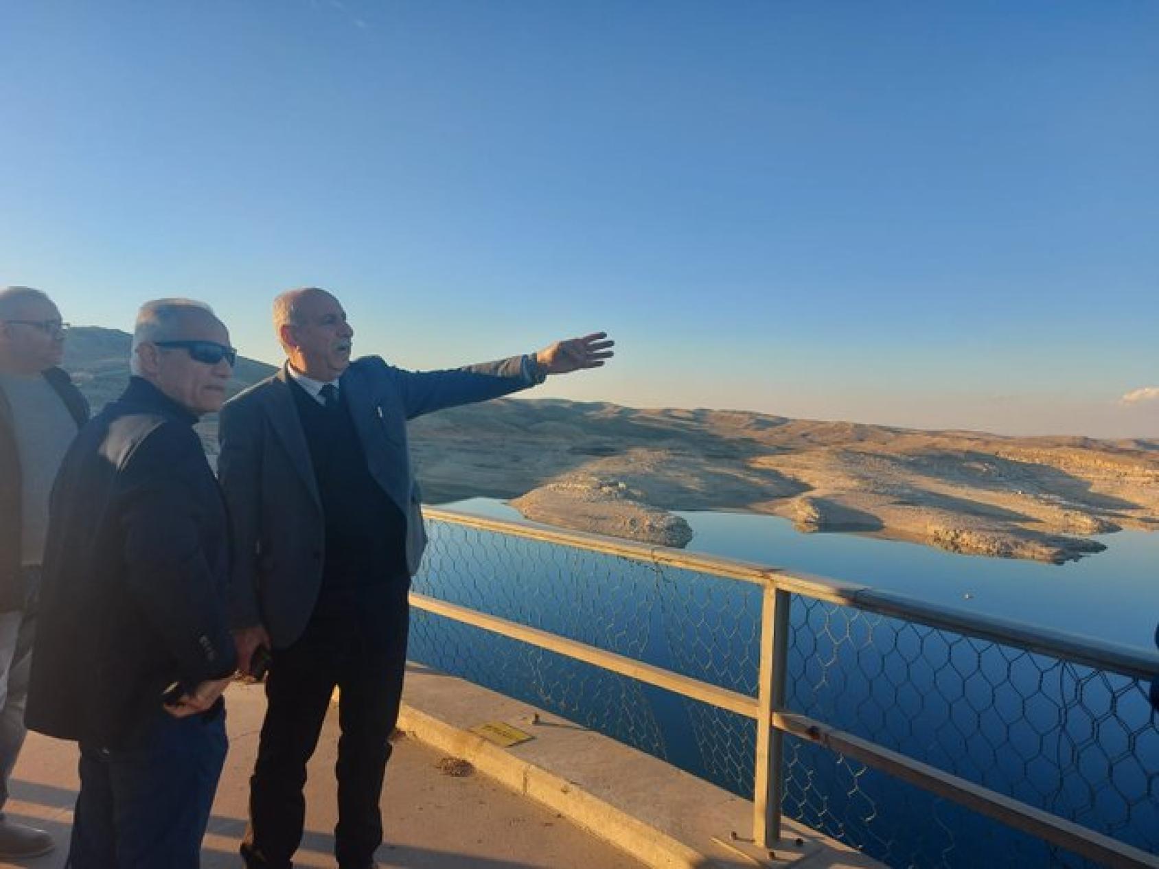 A man is standing by a body of water 