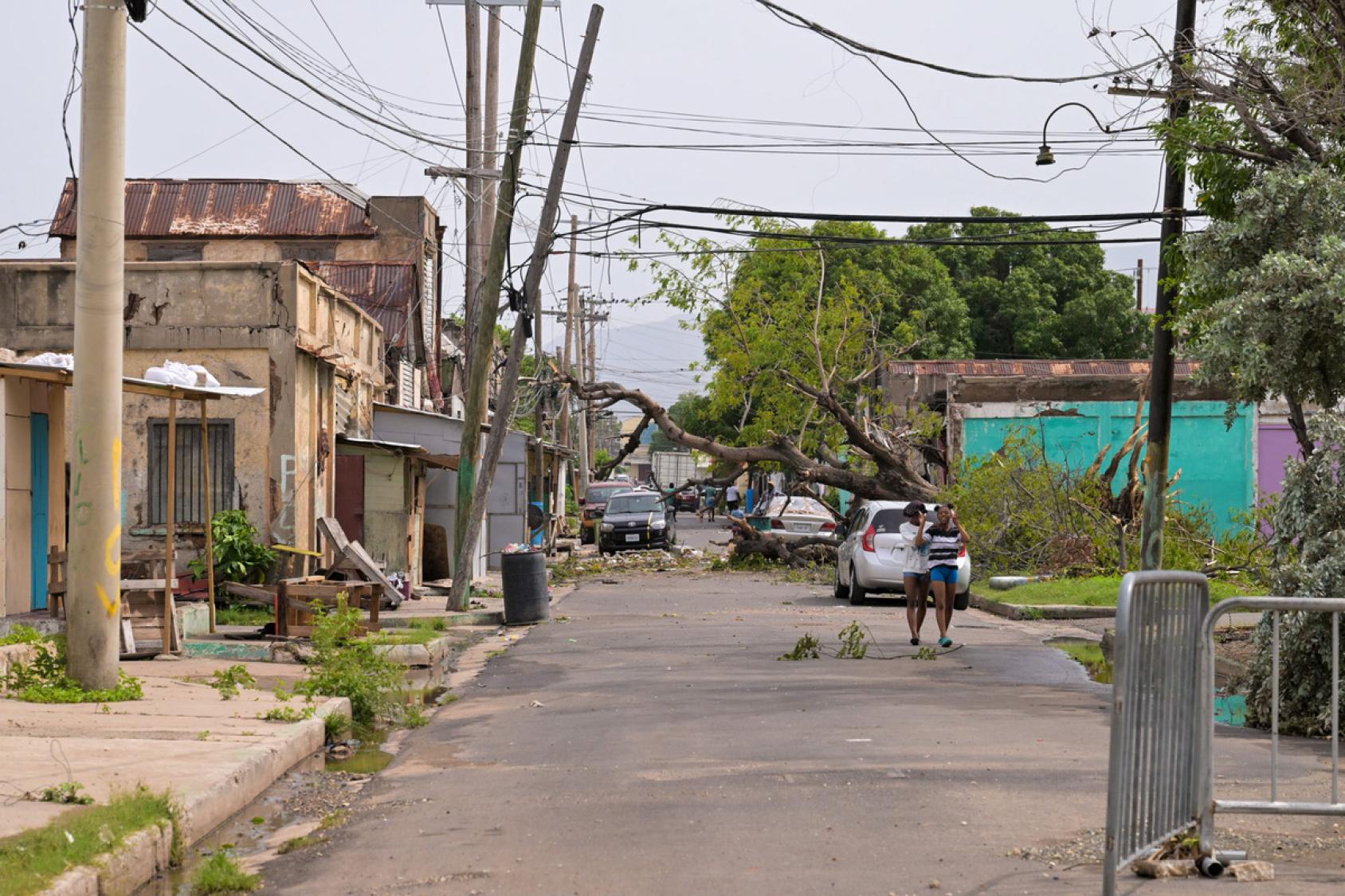 A completely empty road with children walking amidst the distruction