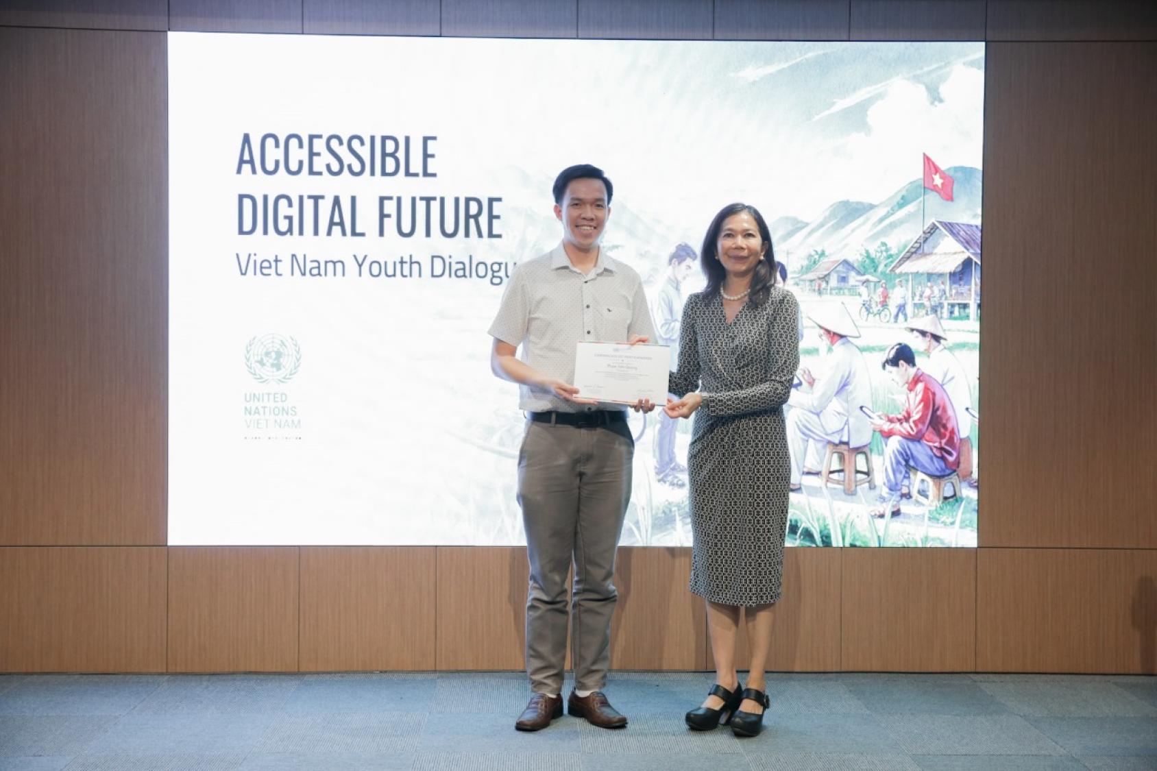 The RC is presenting a young person a certificate on stand, behind them is a banner that reads Digital Future - Viet Nam Youth Dialogue