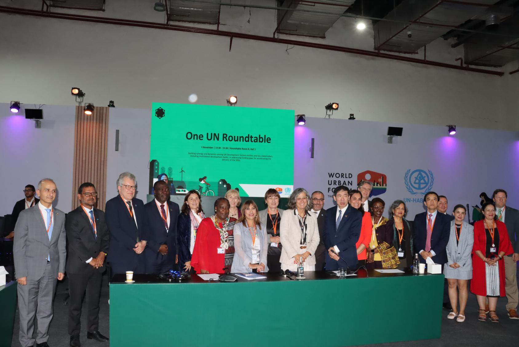 A group of people in front of a banner that reads 'One UN Round Table'