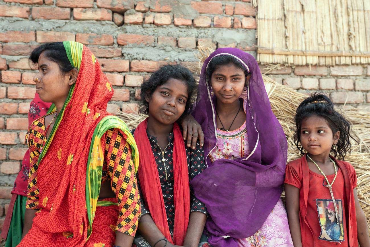 Group of children stand against a brick wall 