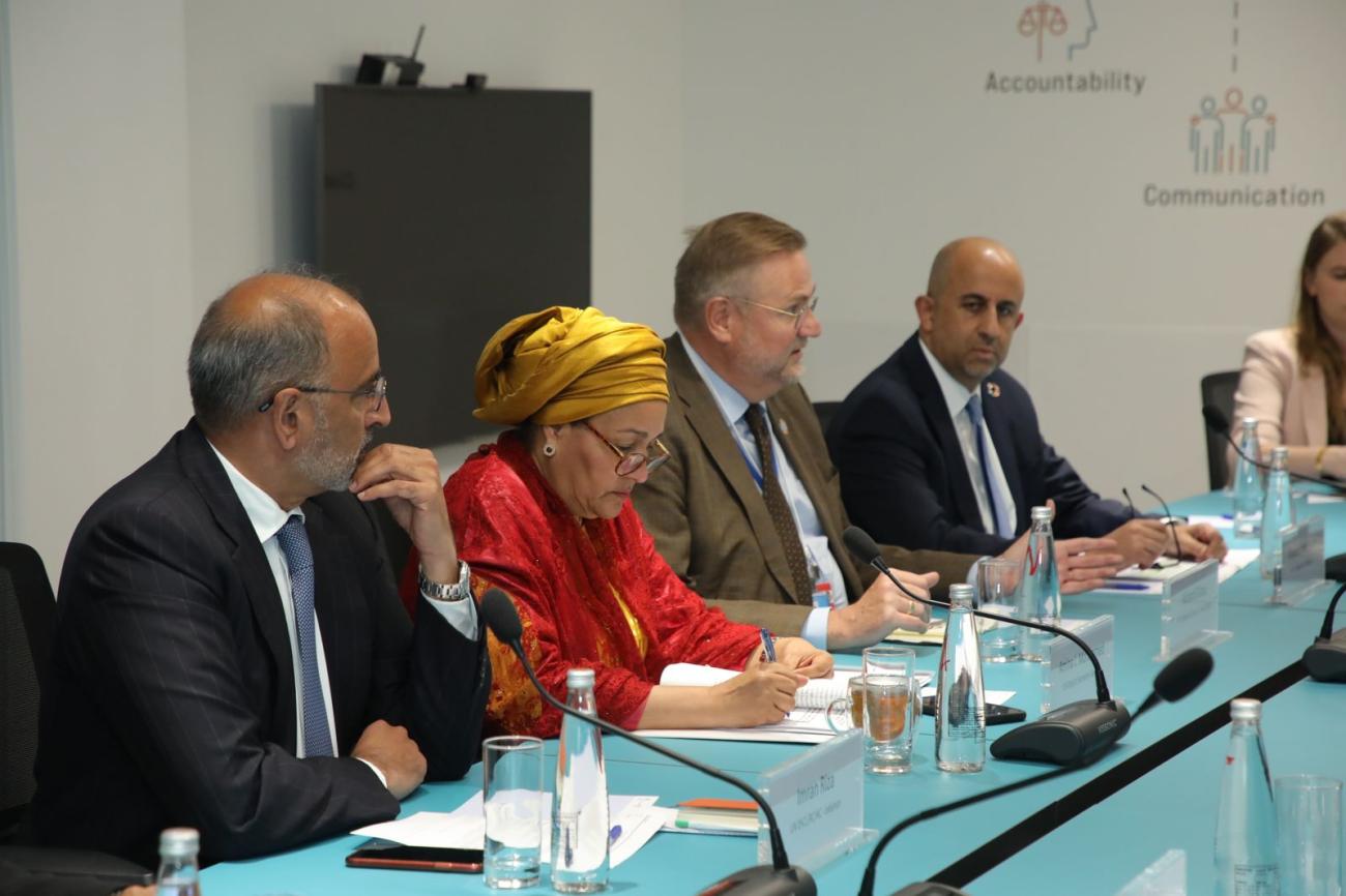 group of three men and one woman sit at panel discussion