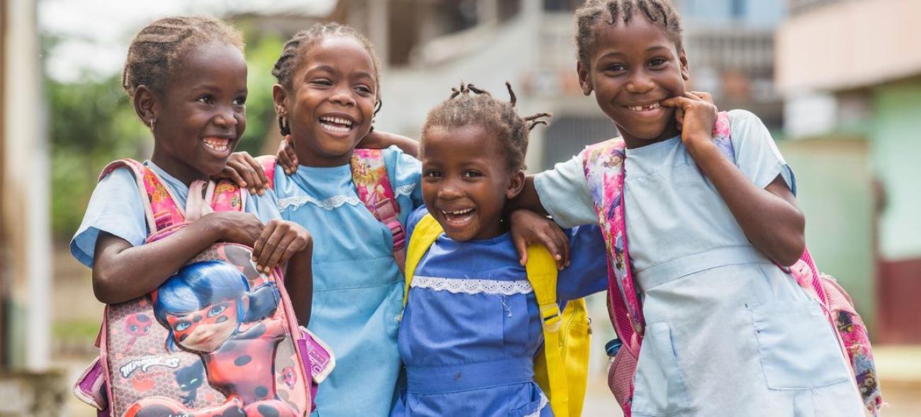 group of young children standing in a group with their arms around each other 