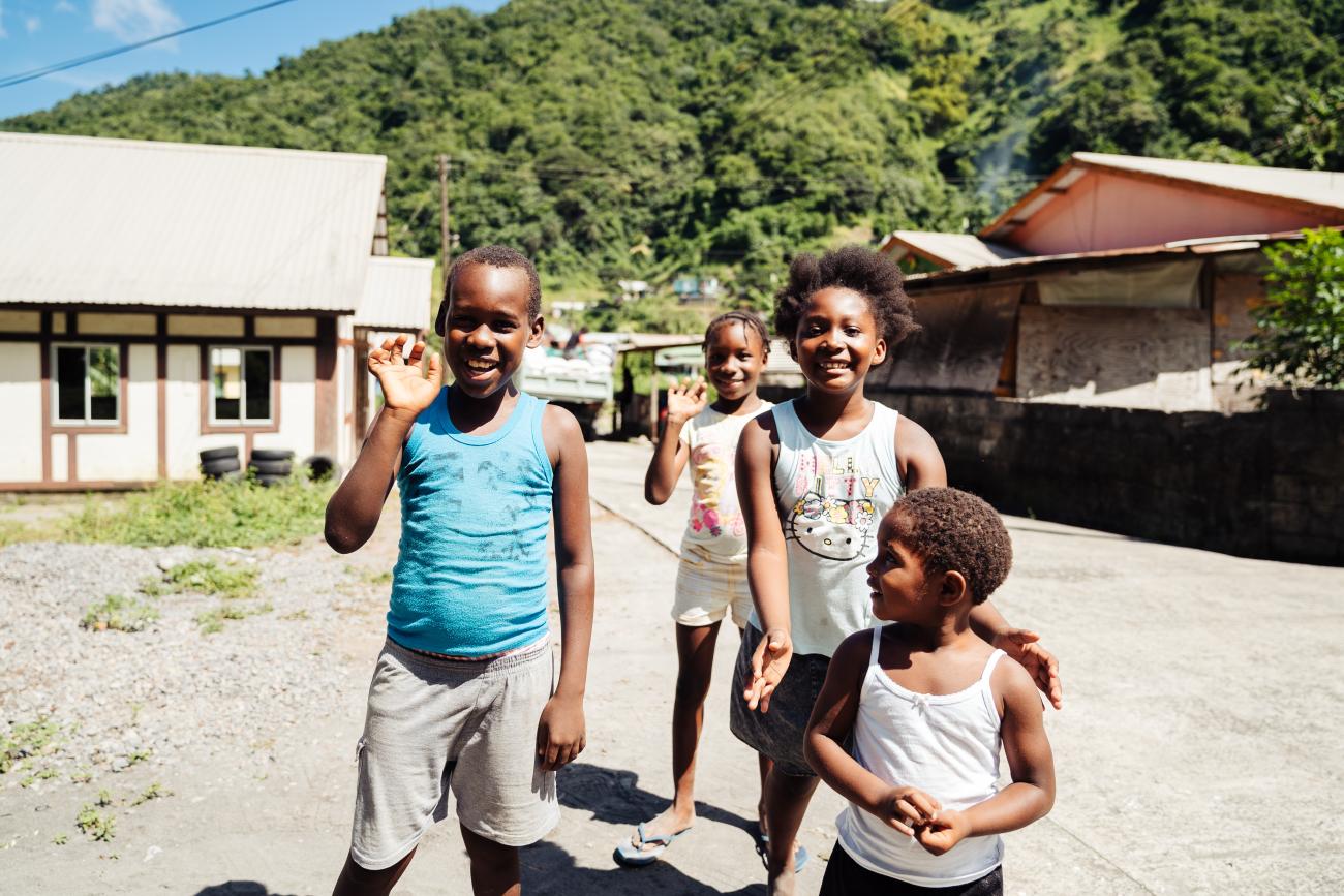 group of children stand on a road playing 