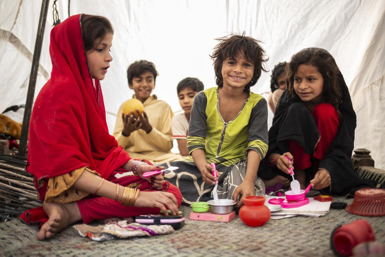 children sit in a tent 