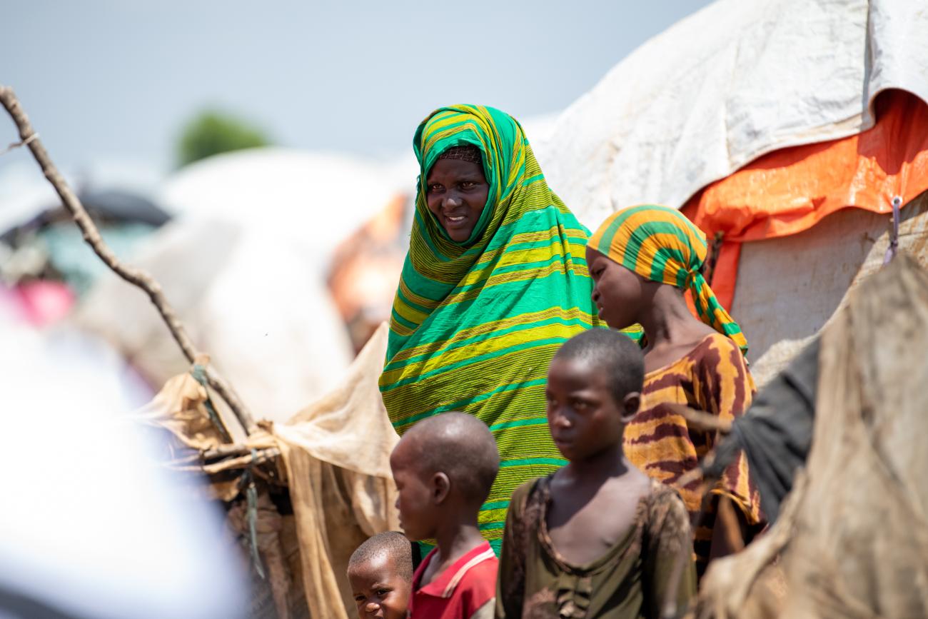 woman in green shall holds a child 