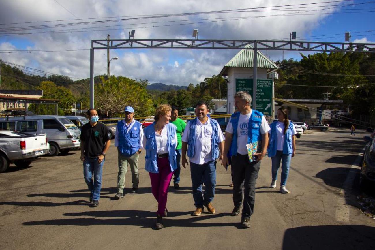 group of people in blue vests walk towards the camera