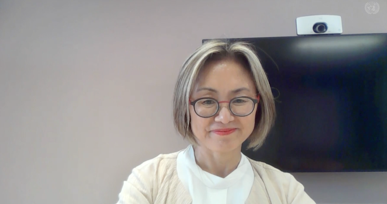 woman in white top looks into the camera 