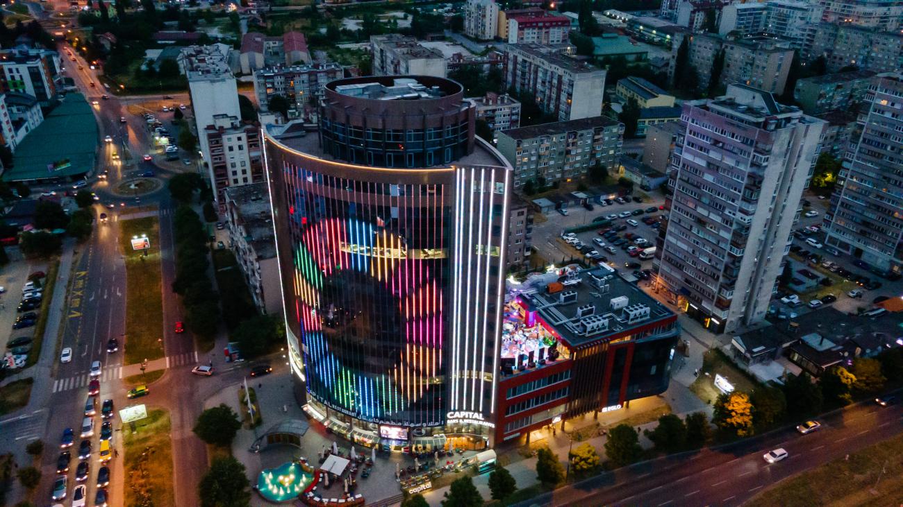 Birdseye view of buildings light up in the dark with SDG symbol 