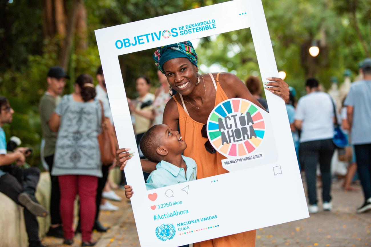 mother and son pose with SDG cut out poster