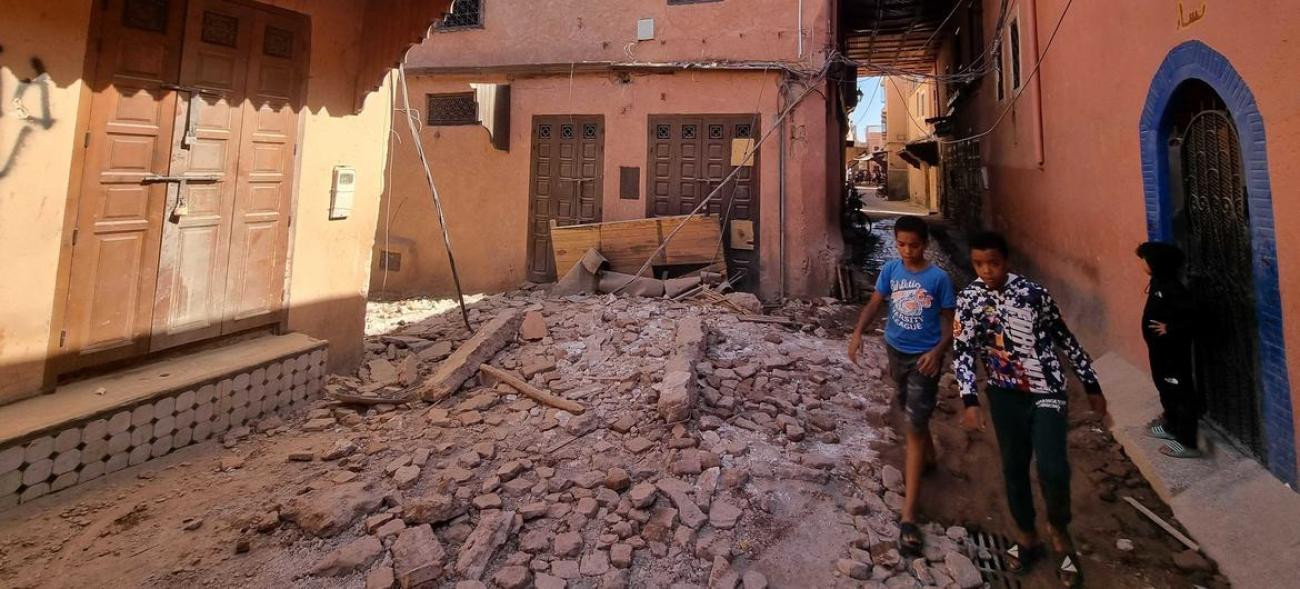 children walk among the rubble of buildings affected by the earthquake in Morocco