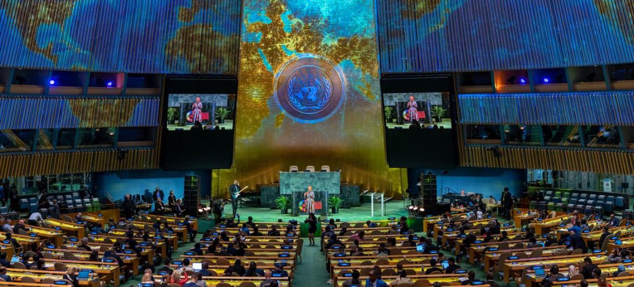 view of UN General Assembly lit up with light projection of the world map